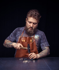 Professional Leather Worker works with leather at his leather shop