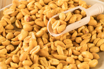 close up, wooden spoon in heap peanuts