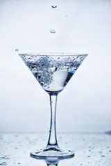 Martini glass with frozen splashing drops of drink