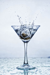 Martini glass with frozen splashing drops of drink