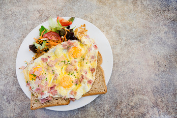plate with ham cheese omelet with salad on slice of bread