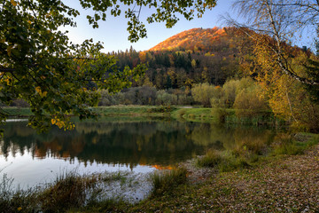 View of the lake at the foot of the mountains in the autumn season. - 269241259