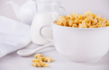 A bowl of dry star shaped cereal and a bottle of milk