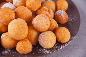 Plate with small balls of freshly baked homemade cottage cheese doughnuts