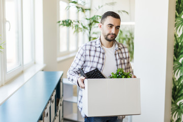 Business, firing and job loss concept. Fired male office worker with box of his personal stuff