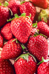 Bright background of ripe and fresh strawberries. Closeup ready for eat tasty beautiful appetizing juicy strawberries with leaves