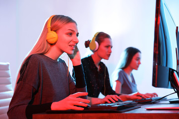 Young people playing video games on computers indoors. Esports tournament