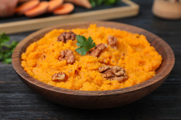 Bowl with mashed sweet potatoes on wooden table