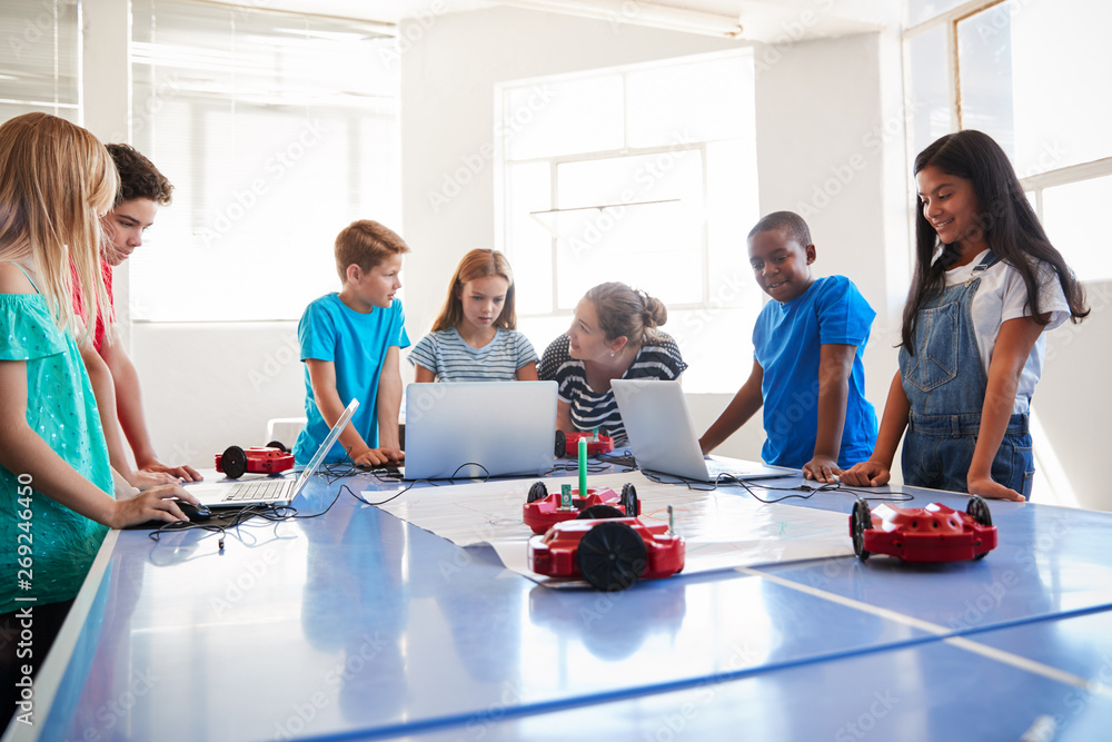 Wall mural Group Of Students In After School Computer Coding Class Learning To Program Robot Vehicle