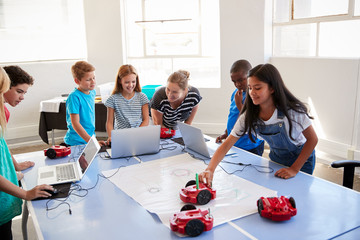 Group Of Students In After School Computer Coding Class Learning To Program Robot Vehicle