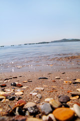 Exotic rocky beach with colorful stones, tropical blue sea with waves and foam. Beautiful natural environment, panorama, landscape. Idyllic seaside resort in summer season, paradise, amazing scene.