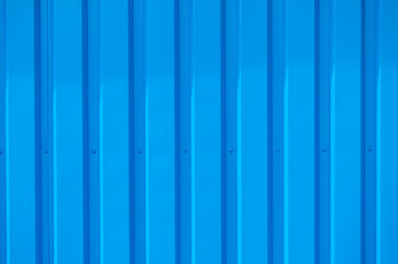 Close up photo of a facade from an industrial building with graphic stripes of minimalistic vertical blue metal profiles. Background image.