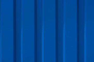 Close up photo of a facade from an industrial building with graphic stripes of minimalistic vertical blue metal profiles. Background image.
