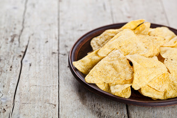 Nachos chips on brown ceramic plate.