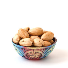 clay bowl with pecan nuts in shell on white background