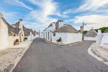 Beautiful town of Alberobello with Trulli houses among green plants and flowers, Apulia region,...