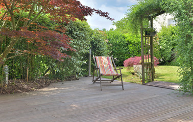 deck chair on a wooden terrace in a landscaped garden