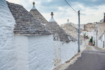 Beautiful town of Alberobello with Trulli houses among green plants and flowers, Apulia region,...
