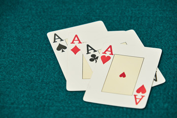 on the green table, a set of four aces stands out, to the right of the image leaving large space for inscriptions.