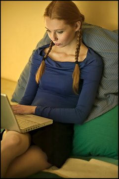 Young Redhead With Pigtails Using Laptop