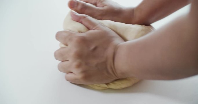 Close up women kneading the dough with hands on a white table, Slow Motion, 4K