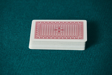 a deck of red cards on the green game mat