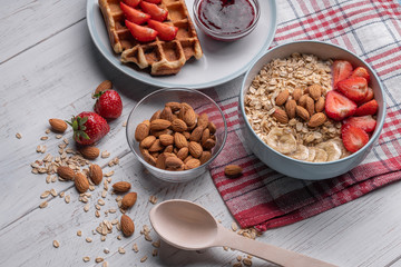 Oatmeal. Breakfast food. Fresh waffles and muesli on morning meal. Granola with fruit and almond. On white background