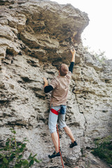 Brave young man climbs the cliff