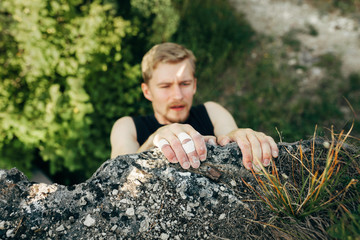 Brave young man climbs the top of the cliff