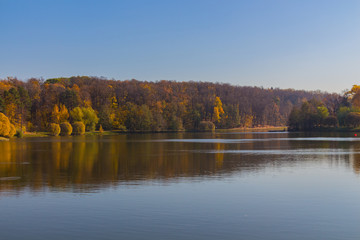Naklejka na ściany i meble Scenic view to the autumn park and pond, golden autumn
