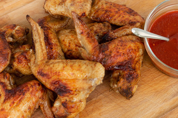 Chicken wings with sriracha sauce on wooden desk