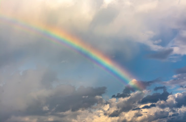 Rainbow in the spring cloudy sky after a thunderstorm.