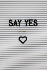 Engagement ring on a bulletin board with love message. Proposal concept.