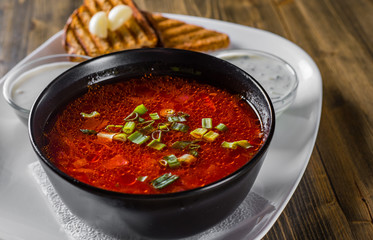 Beetroot soup Traditional Ukrainian or Russian borscht with sour cream in a bowl on wooden table