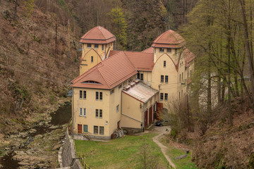 Fototapeta premium LEŚNA, POLAND - April, 2019: Small hydropower plant Leśna, view of the dam and the room with hydro turbines and generators. Development of hydroelectric generation facilities. The oldest in Poland