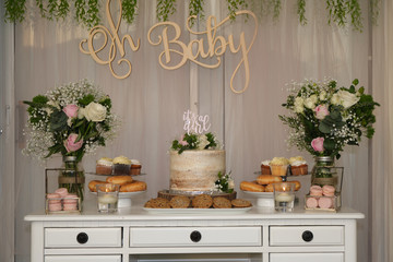 Fototapeta na wymiar Baby shower cake table, rustic garden decor.