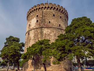 White Tower of Thessaloniki - medieval prison tower, now a museum, surrounded by trees - Thessaloniki, Greece