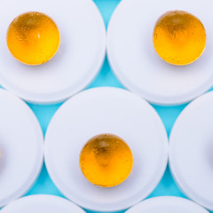 Background of drugs on a blue background.Bowl of fish oil on a white background close-up.Top view of fish oil for good health on white background. Extra food.