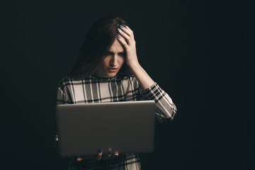 Teen girl excessively sitting at the computer laptop at home. he is a victim of online bullying Stalker social networks