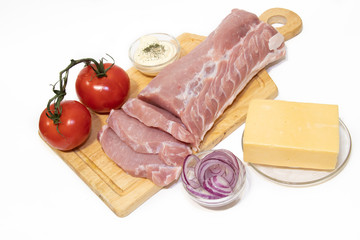 Pork chop isolated on white background. Meat on a white background. Raw meat and red tomatoes. Tomatoes on the branch.