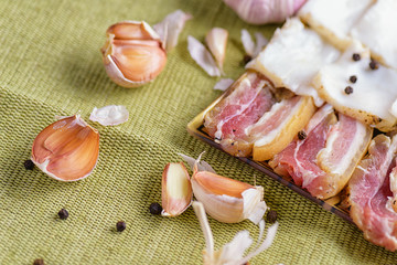  Fresh bacon in plate. Bacon with garlic. Bacon sliced and sliced garlic.