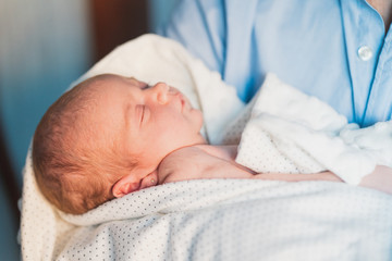 New father sleeping his cute adorable newborn on his lap. Baby expresses calm and peace. Social and Gender equality. Family, new life, childhood, beginning concept.