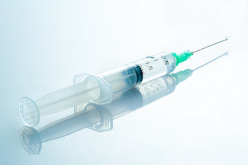 Syringe with medicinal solution, on a light blue background with reflection. 2 ml syringe macro close up