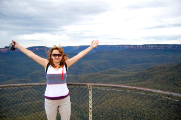 Woman with outstretched arms with mountains on the background