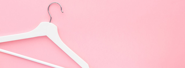 White hangers on pastel pink background