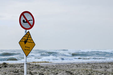 Sign warning of strong currents, and prohibiting swimming against a stormy sea