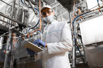man in a white robe and a cap make an inspection of the production line