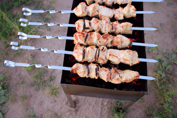 Skewers on skewers on the grill. Grilled meat on the coals. Marinated meat.