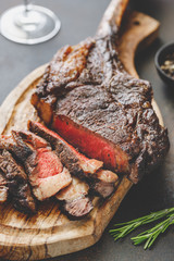 Dry-aged marble beef steak Tomahawk on wooden board with spices. Close-up, dinner concept.
