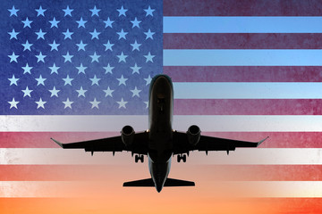airplane on sunset sky with American flag - USA travel concept -